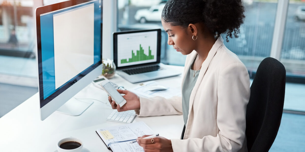 Shot of a young businesswoman using a mobile phone at her desk in a modern office